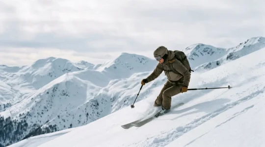 Expert skier navigating steep mountain terrain on a challenging black run in North Macedonia with dramatic alpine peaks in the background