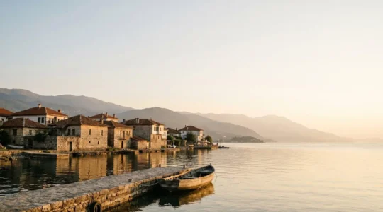 Scenic view of Lake Ohrid with traditional Balkan architecture and mountain ranges in North Macedonia, wide editorial composition with natural lighting