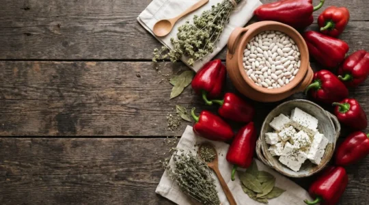 Traditional Macedonian food spread featuring red peppers, clay pot dishes, and rustic table setting showcasing Balkan culinary heritage