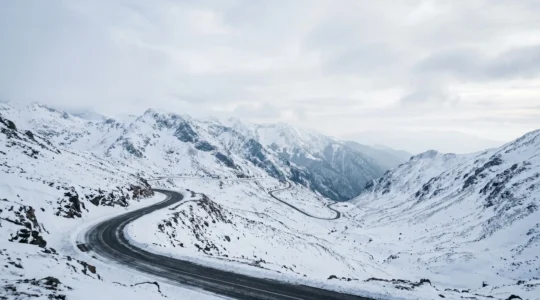 Mountain road winding through snowy Macedonian peaks with winter driving conditions